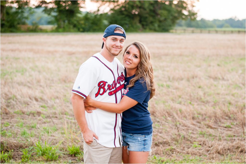 Fairview Farm summer sunset in field with Atlanta braves gear on engagement photo